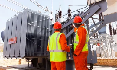 electricians standing next to a transformer in electrical power plant