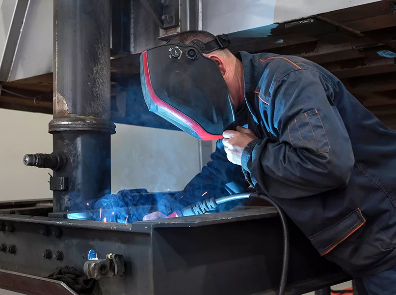 A mechanic in a protective welding mask