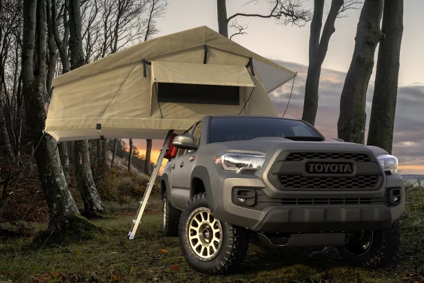 Toyota Tacoma with a tent at a forest camp